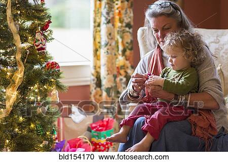 Caucasian grandmother and grandson opening presents near Christmas tree View Large Photo Image Stock Image - Caucasian grandmother and grandson opening presents near Christmas tree. Fotosearch