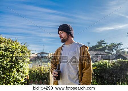 Caucasian man drinking beer in backyard View Large Photo Image Stock Image - Caucasian man drinking beer in backyard. Fotosearch