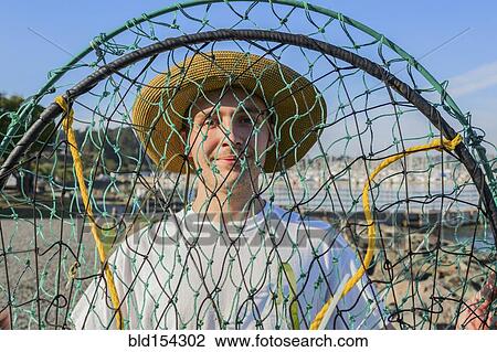 Stock Image - Caucasian man holding fishing net. Fotosearch