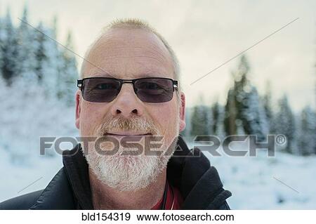 Stock Photo - Caucasian man in snowy field. Fotosearch