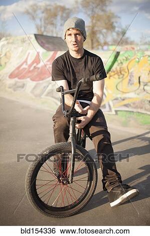 Stock Photograph - Caucasian man riding BMX bicycle at skate park. Fotosearch