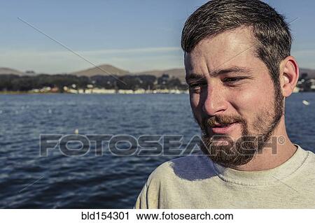 Stock Image - Caucasian man standing near bay. Fotosearch