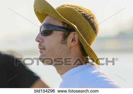 Stock Photograph - Caucasian man wearing sun hat and sunglasses. Fotosearch