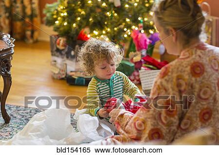 Caucasian mother and baby son opening presents near Christmas tree View Large Photo Image Stock Photography - Caucasian mother and baby son opening presents near Christmas tree. Fotosearch