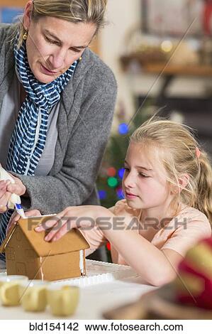 Caucasian mother and daughter decorating gingerbread house View Large Photo Image Stock Image - Caucasian mother and daughter decorating gingerbread house. Fotosearch