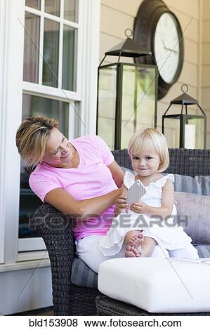 Caucasian mother and daughter using cell phone on porch View Large Photo Image Stock Photo - Caucasian mother and daughter using cell phone on porch. Fotosearch