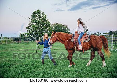 Caucasian mother and daughter walking horse on ranch View Large Photo Image Stock Image - Caucasian mother and daughter walking horse on ranch. Fotosearch