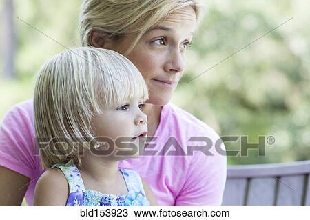 Stock Image - Caucasian mother holding daughter. Fotosearch