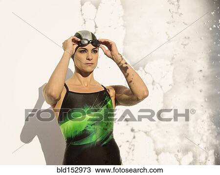 Stock Image - Caucasian swimmer standing near splashing water. Fotosearch
