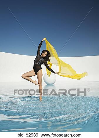 Stock Photo - Caucasian woman dancing with fabric on water surface. Fotosearch