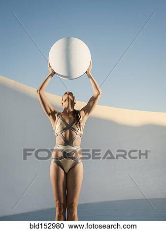 Caucasian woman holding sphere in swimming pool View Large Photo Image Stock Image - Caucasian woman holding sphere in swimming pool. Fotosearch