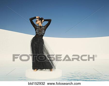 Stock Image - Caucasian woman in evening gown on ice floe. Fotosearch