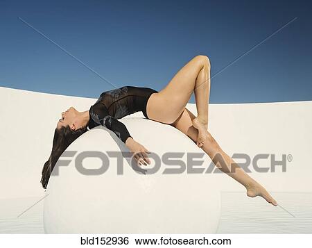 Caucasian woman laying on sphere View Large Photo Image Stock Photograph - Caucasian woman laying on sphere. Fotosearch