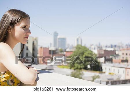 Caucasian woman overlooking cityscape from urban rooftop View Large Photo Image Stock Image - Caucasian woman overlooking cityscape from urban rooftop. Fotosearch