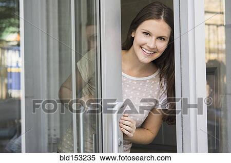 Stock Photography - Caucasian woman peeking out doorway. Fotosearch