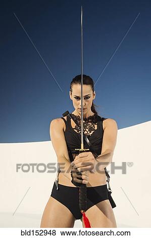 Stock Photo - Caucasian woman posing with sword. Fotosearch