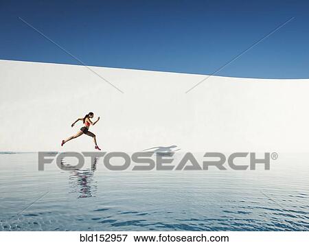 Caucasian woman running on water surface View Large Photo Image Stock Photo - Caucasian woman running on water surface. Fotosearch
