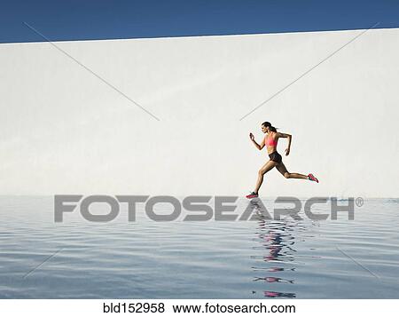 Stock Photo - Caucasian woman running on water surface. Fotosearch