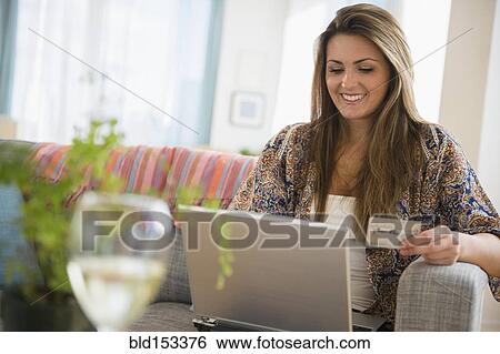 Stock Photograph - Caucasian woman shopping online with laptop. Fotosearch