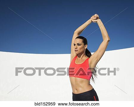 Caucasian woman stretching under blue sky View Large Photo Image Stock Photo - Caucasian woman stretching under blue sky. Fotosearch