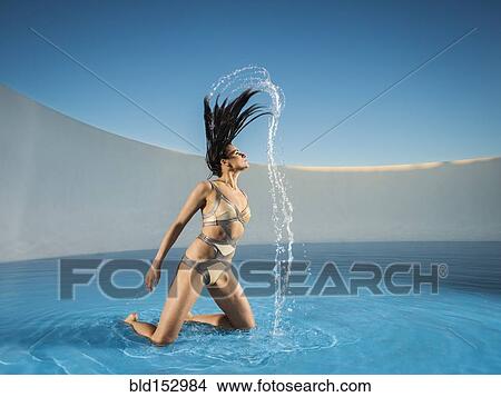 Caucasian woman tossing hair on swimming pool View Large Photo Image Picture - Caucasian woman tossing hair on swimming pool. Fotosearch