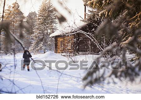 Caucasian woman walking near log cabin in snowy forest View Large Photo Image Stock Photograph - Caucasian woman walking near log cabin in snowy forest. Fotosearch