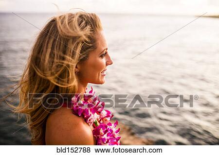 Caucasian woman wearing flower lei by ocean View Large Photo Image Stock Photo - Caucasian woman wearing flower lei by ocean. Fotosearch