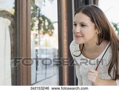 Stock Photograph - Caucasian woman window shopping outside store. Fotosearch