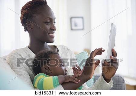 Close up of Black mother and baby boy using digital tablet View Large Photo Image Stock Image - Close up of Black mother and baby boy using digital tablet. Fotosearch