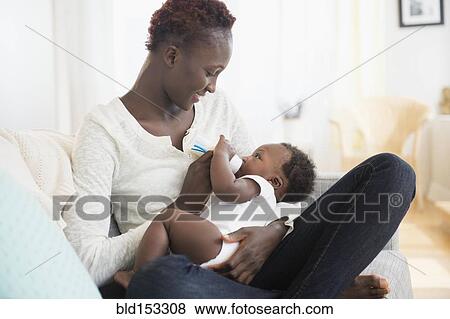 Stock Photo - Close up of Black mother feeding baby boy. Fotosearch