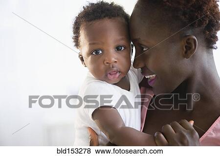 Close up of Black mother holding son View Large Photo Image Stock Photo - Close up of Black mother holding son . Fotosearch