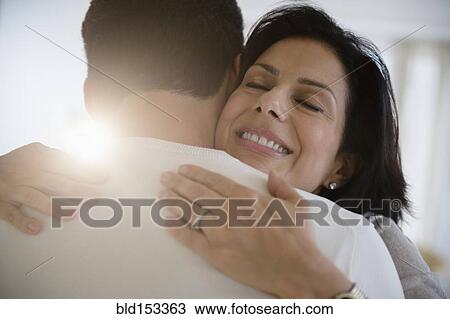 Stock Image - Close up of couple hugging. Fotosearch