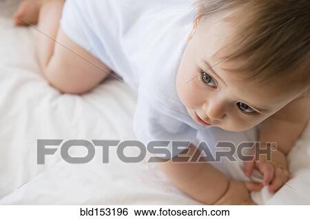 Close up of mixed race baby crawling on bed View Large Photo Image Stock Photograph - Close up of mixed race baby crawling on bed. Fotosearch