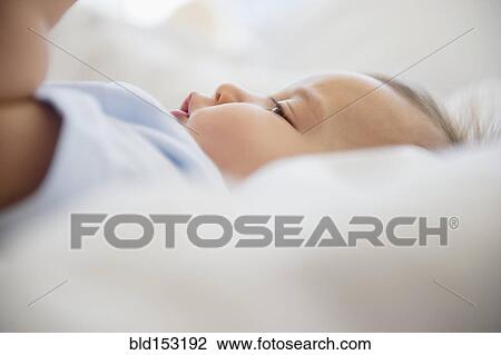 Close up of mixed race baby laying on bed View Large Photo Image Stock Image - Close up of mixed race baby laying on bed. Fotosearch