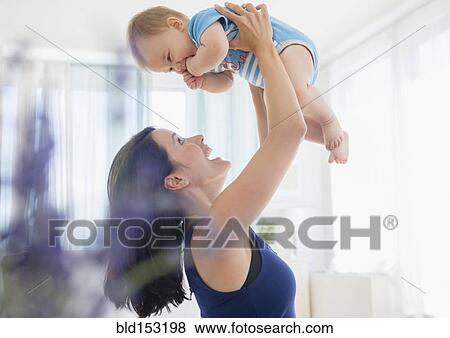 Stock Photo - Close up of mixed race mother playing with baby. Fotosearch