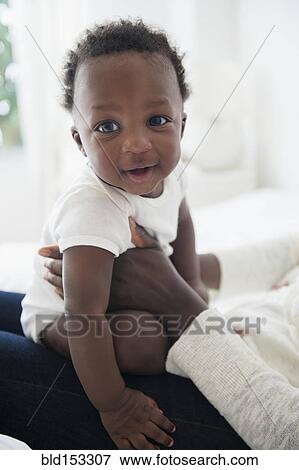 Close up of mother holding smiling Black baby boy View Large Photo Image Stock Photo - Close up of mother holding smiling Black baby boy. Fotosearch
