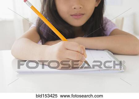 Stock Photography - Close up of Vietnamese girl doing homework. Fotosearch