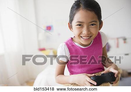 Close up of Vietnamese girl playing video game View Large Photo Image Stock Photo - Close up of Vietnamese girl playing video game. Fotosearch