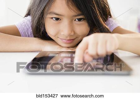 Stock Photo - Close up of Vietnamese girl using digital tablet. Fotosearch