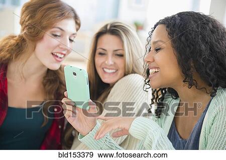 Close up of women using cell phone View Large Photo Image Stock Photo - Close up of women using cell phone. Fotosearch