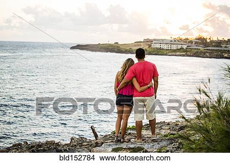 Couple enjoying scenic view of beach View Large Photo Image Picture - Couple enjoying scenic view of beach. Fotosearch