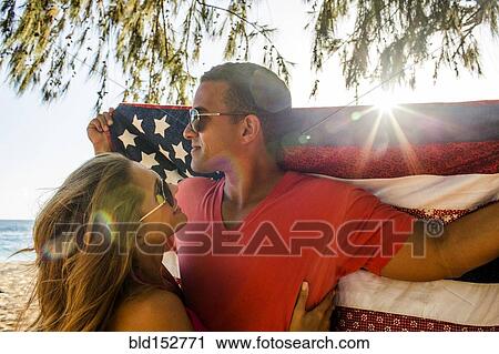Stock Image - Couple holding American flag quilt. Fotosearch