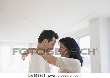 Stock Image - Couple hugging indoors. Fotosearch