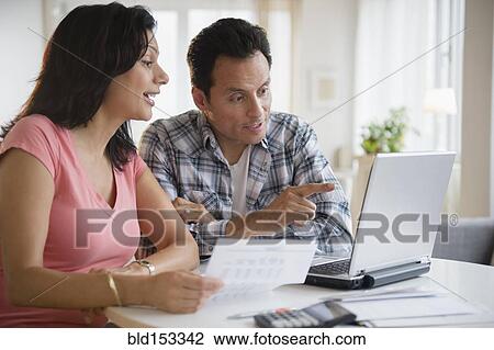 Stock Image - Couple paying bills online. Fotosearch