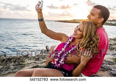 Couple taking cell phone photograph on beach View Large Photo Image Stock Image - Couple taking cell phone photograph on beach. Fotosearch