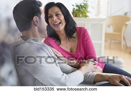 Couple talking on sofa in living room View Large Photo Image Stock Photography - Couple talking on sofa in living room. Fotosearch