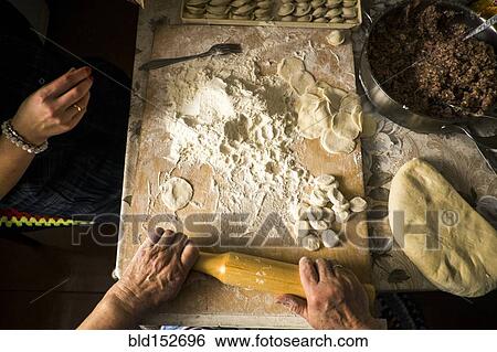 High angle view of family rolling pastry dough at kitchen table View Large Photo Image Stock Photograph - High angle view of family rolling pastry dough at kitchen table. Fotosearch
