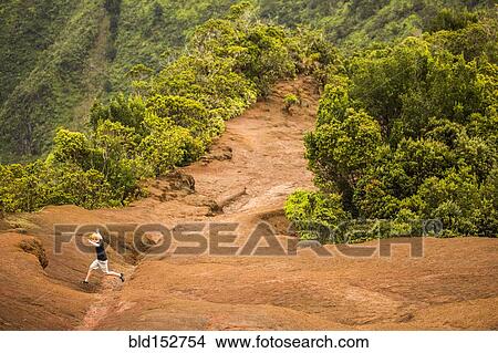 Picture - High angle view of man jumping on remote mountainside. Fotosearch