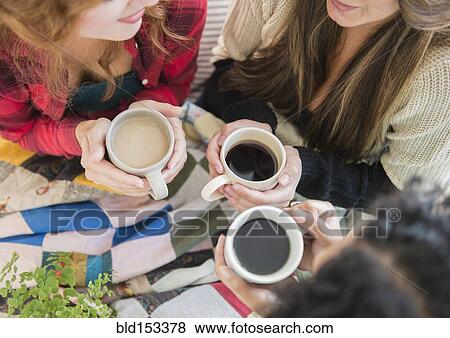 Stock Photo - High angle view of women drinking coffee. Fotosearch
