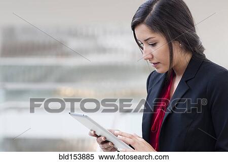 Hispanic businesswoman using digital tablet View Large Photo Image Stock Photography - Hispanic businesswoman using digital tablet. Fotosearch